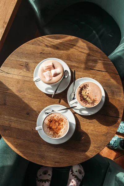 Cocoa in large white cup on table in cafe. Cocoa with marshmallows, peppers and cinnamon.