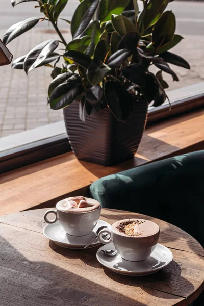 Cocoa in large white cup on table in cafe. Cocoa with marshmallows, peppers.