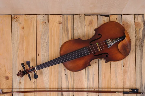 En violin bild på trä bakgrund och båge — Stockfoto
