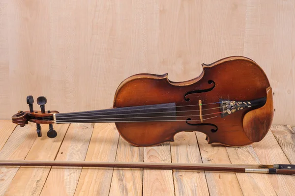 En violin bild på trä bakgrund och båge — Stockfoto