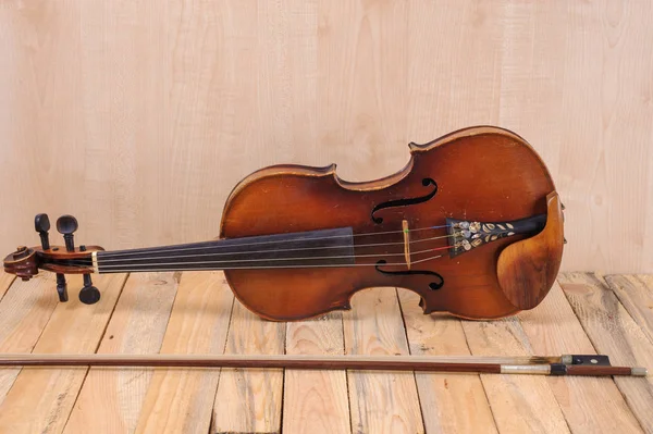 Un'immagine di violino sullo sfondo di legno e arco Immagine Stock