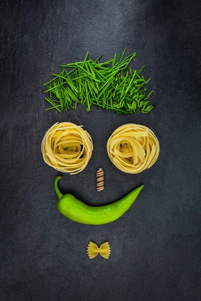 Biber chives ve makarna gri kayrak üzerine yapılmış yüz 