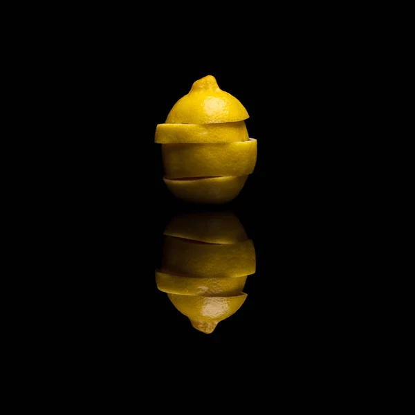 一个孤立的黄色柠檬切成片在黑色反光背景上 — 图库照片