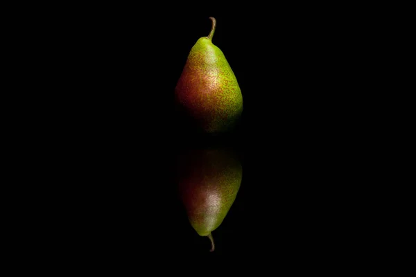 En helt röd och grön päron isolerad på svart reflekterande bakgr — Stockfoto
