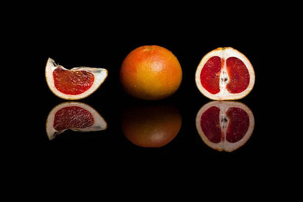 Siyah arka plan üzerine izole bütün ve dilim greyfurt