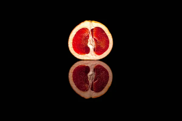Yarım kırmızı greyfurt siyah arka plan üzerine izole kesmek