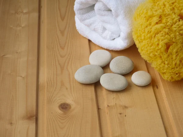 Handduk, stenar och svamp i trä bakgrunden — Stockfoto