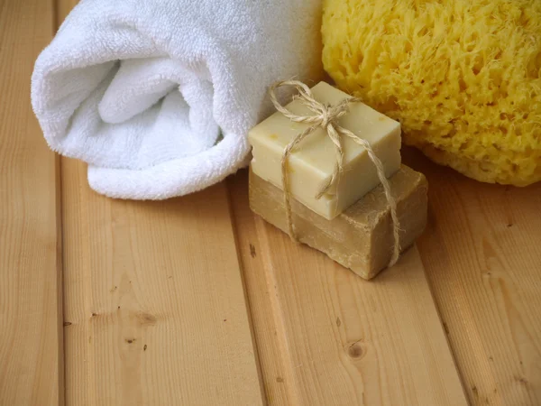 Handduk, tvål och svamp i trä bakgrunden — Stockfoto