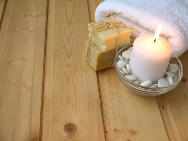 毛巾, 肥皂和燃烧的蜡烛在木背景 — 图库照片