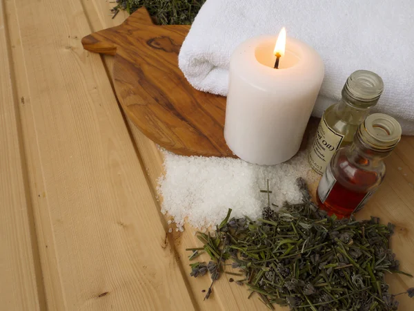 Aceites de masaje, velas y toallas en el fondo de madera — Foto de Stock