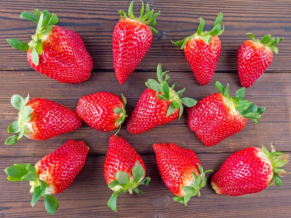 Fresas en el tablero de madera de textura oscura — Foto de Stock