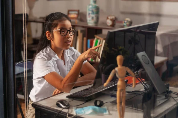 Kız evde online ders çalışıyor, evde kalıyor. COVID-19 salgını çocukları ve öğretmenleri çevrimiçi öğrenmeye zorluyor.