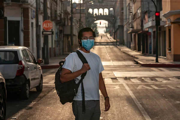 Guatemala şehrinin boş bir caddesinde maskeli genç adam covid-19 ya da coronavirus yüzünden.