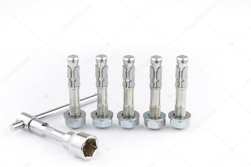 Expansion anchors on a white background and a ratchet wrench