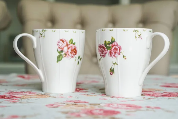 Чашка на квітковій скатертині — стокове фото