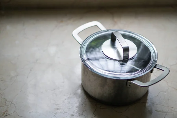 old aluminum stainless steel cooking pot on kitchen table