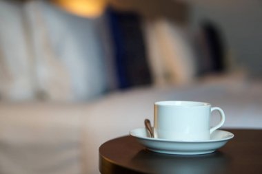 otel odasında bir kanepe koltuk tarafından masada beyaz kahve fincanı