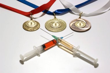 Beyaz zemin üzerinde üç altın madalya yakınındaki bir doping olarak iki renkli şırıngalar içinde popüler steroid