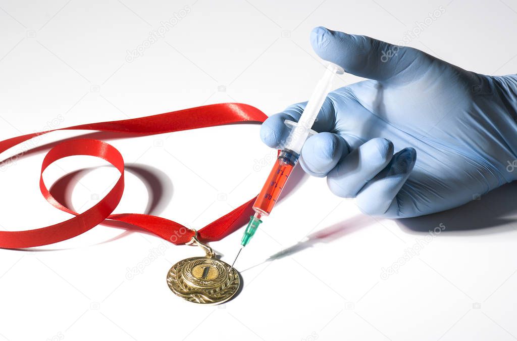 A hand in medical glove stabs a gold medal with popular red steroid in syringe on a white background