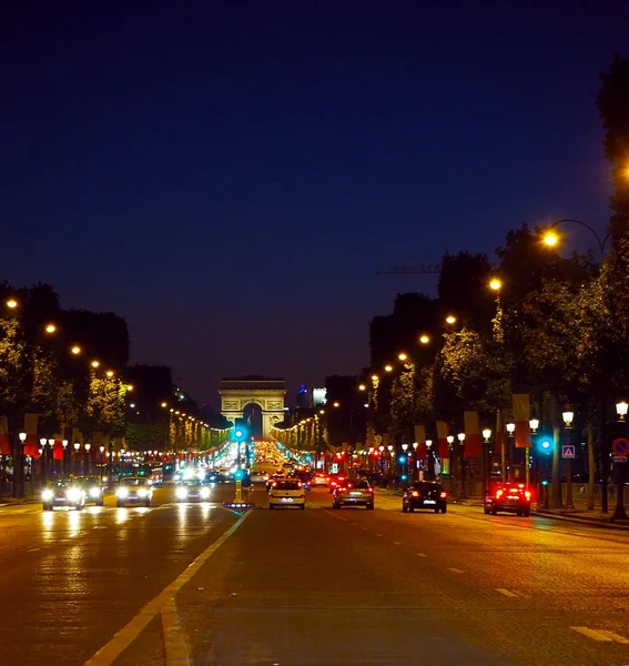 Avenida Champs-Elysees com iluminação e arco triunfal no horizonte em Paris, França. Champs Elysees é uma das ruas mais famosas e famosas do mundo . — Fotografia de Stock