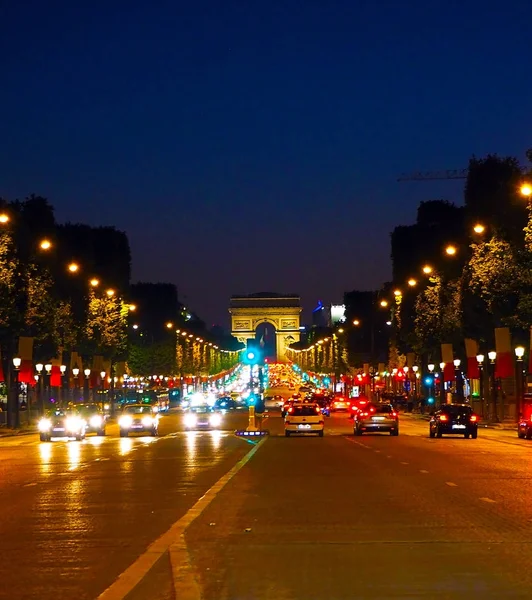 Avenue Champs-Elysees with illumination and triumphal arch on the horizon in Paris, France. Champs Elysees is one of the most famous and famous streets in the world. — Stock Photo, Image