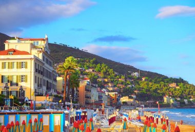 Çok renkli şemsiye plajda Alassio, Savona eyaletinde, Sanremo bölgesi, İtalya. Gün batımında şehir