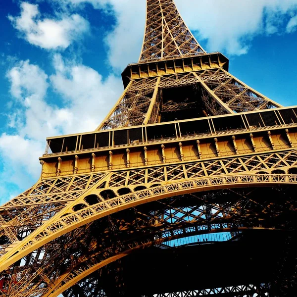 Feche a parte do elemento da torre Eiffel contra um céu azul brilhante com nuvens. Festa de primavera em Paris, França — Fotografia de Stock