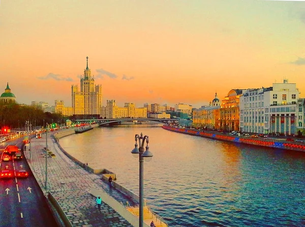 Vista do pôr do sol no rio, um arranha-céu residencial em Kotelnicheskaya Embankment, Rio de Moscou, Bolshoy Ustinsky ponte. Moscou, Rússia — Fotografia de Stock