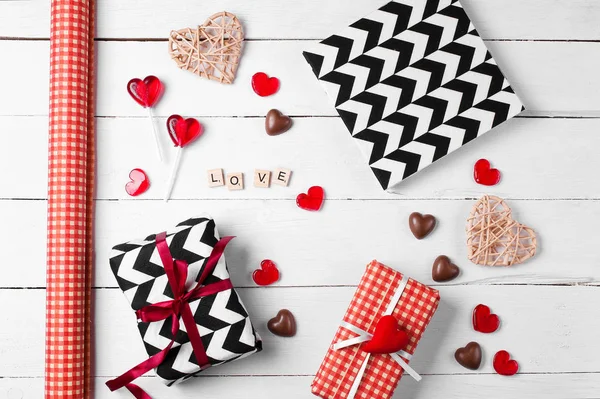 Kırmızı, siyah ve beyaz kağıda sarılmış hediye kutuları.