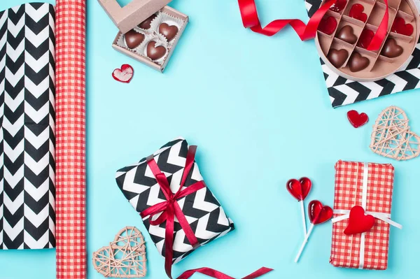 Cajas de regalo envueltas en papel rojo, blanco y negro con caramelos . — Foto de Stock