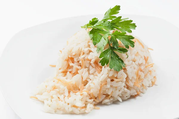 Riso bollito con prezzemolo su un piatto bianco. Fondo bianco — Foto Stock