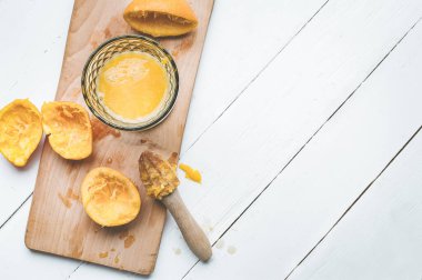 Tahtaya bir bardak meyve suyu ve sıkılmış portakal dilimleri. Beyaz ahşap arka plan. Yukarıdan bak. C vitamini sağlık konsepti.