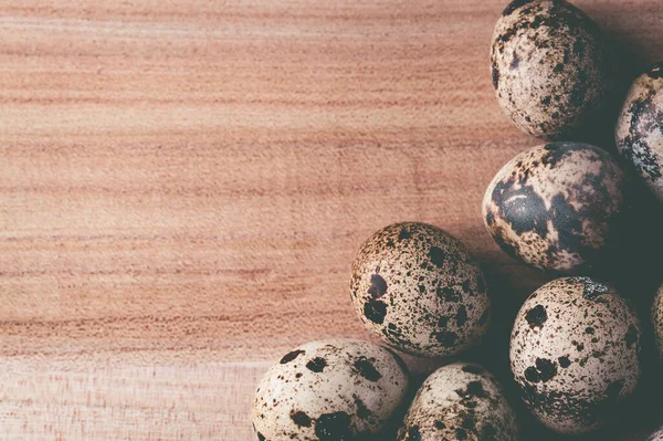 Huevos de codorniz sobre fondo de madera. Foto teñida —  Fotos de Stock