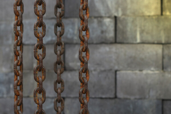 Rusty old chain hanging on over the brick wall background 