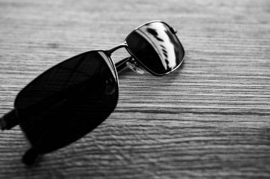 Tek bir basit güneş gözlüğü, ahşap masa üzerinde fotokopi alanı, siyah beyaz