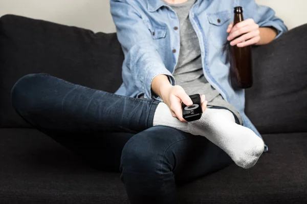 ดูทีวีและดื่มเบียร์บนโซฟา — ภาพถ่ายสต็อก