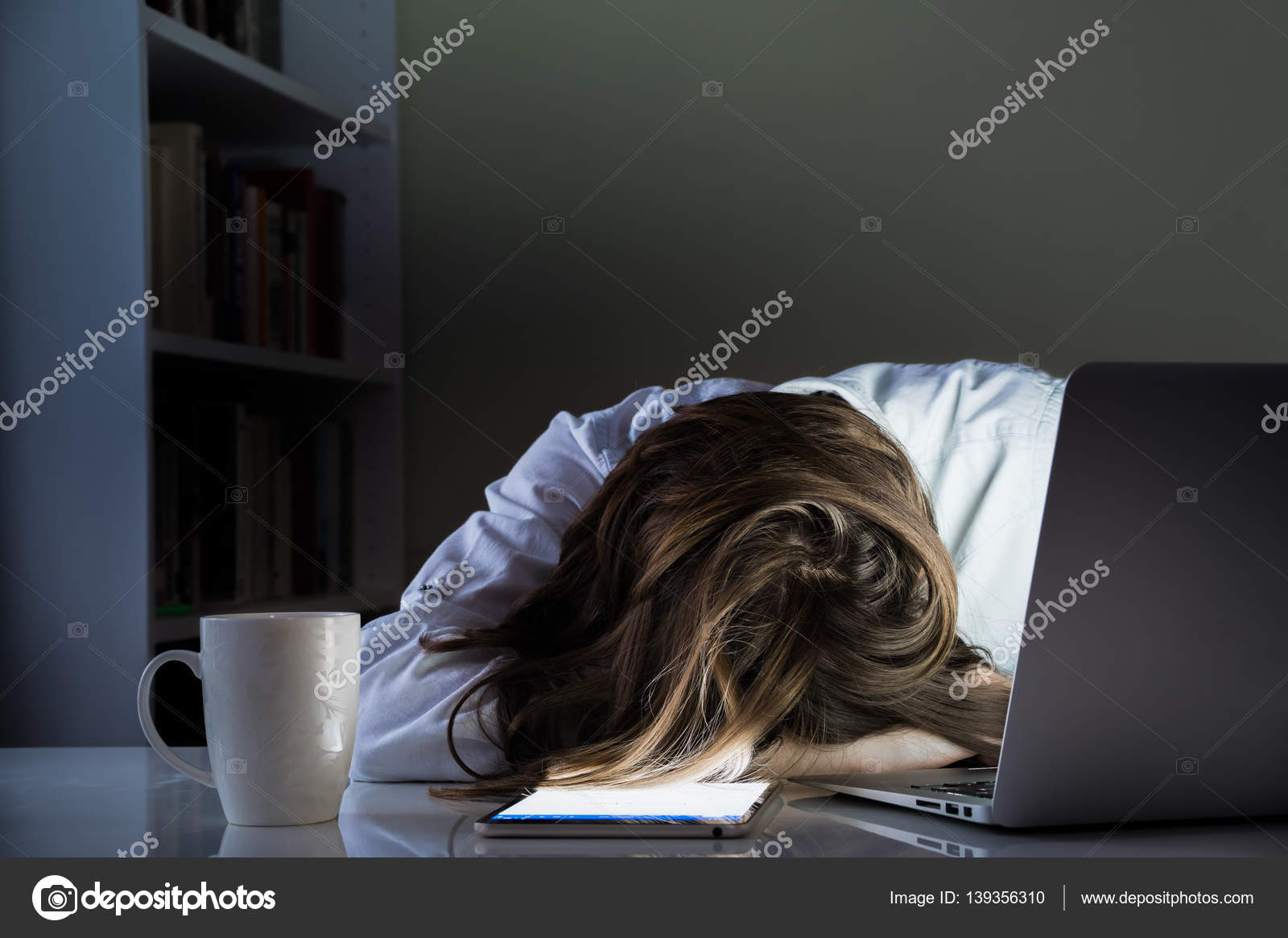 Tired Person Sleeping At Desk In Home Office With Turned On