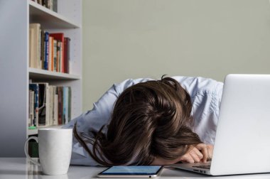 Dizüstü bilgisayar ve tablet Pc önünde masada uyuyan yorgun kız