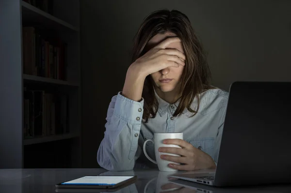 Müde und enttäuschte weibliche Person am Arbeitsplatz zu Hause spät in der Nacht — Stockfoto