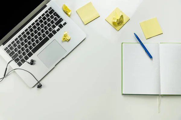 Vista superior del lugar de trabajo de oficina en casa minimalista con ordenador portátil y bloc de notas —  Fotos de Stock