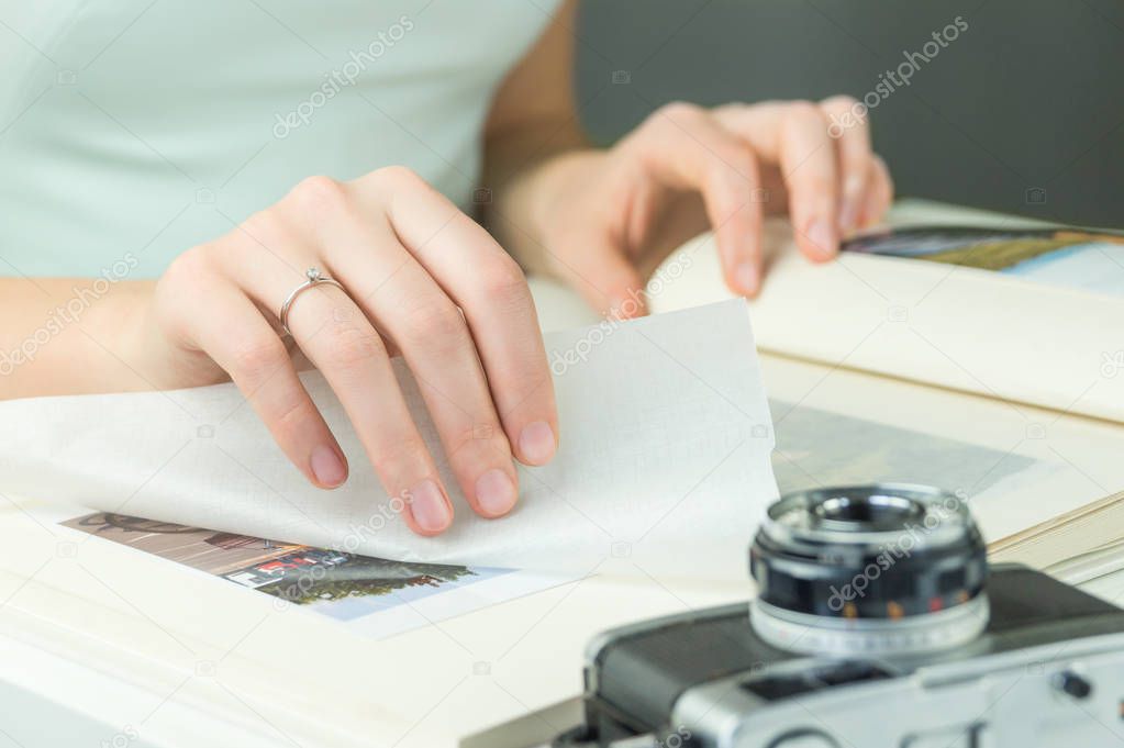 Hand with engagement ring turns page of family photo album