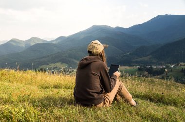 Kız dizüstü bilgisayar dağ tatil sırasında çalışır