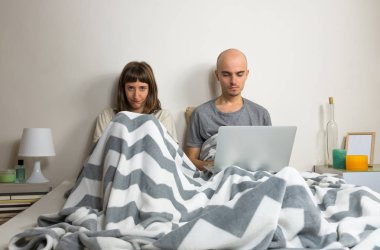 Dizüstü bilgisayar ve kızgın karısı yatakta birlikte tarama web adam