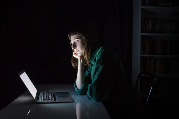 Donna al computer portatile a tarda sera annoiato o la lettura — Foto Stock