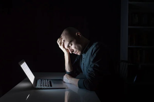 Уставший или измученный человек за компьютером поздно вечером с закрытыми глазами — стоковое фото