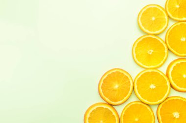 Sliced oranges on green background, top view clipart