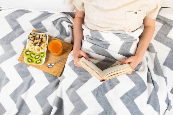 อ่านหนังสือบนเตียง และทานอาหารเช้า ท็อปวิว — ภาพถ่ายสต็อก