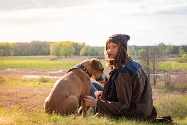 Hermosa chica senderismo sentarse en la colina con perro mascota a pie — Foto de Stock