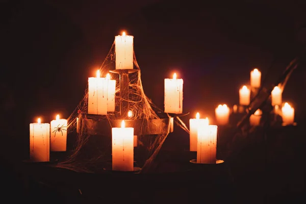 Candles burn in old chandelier in a dark basement. — Stock Photo, Image