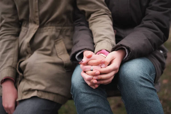 Two women in parka coats holding hands on a walk. — Stock Photo, Image